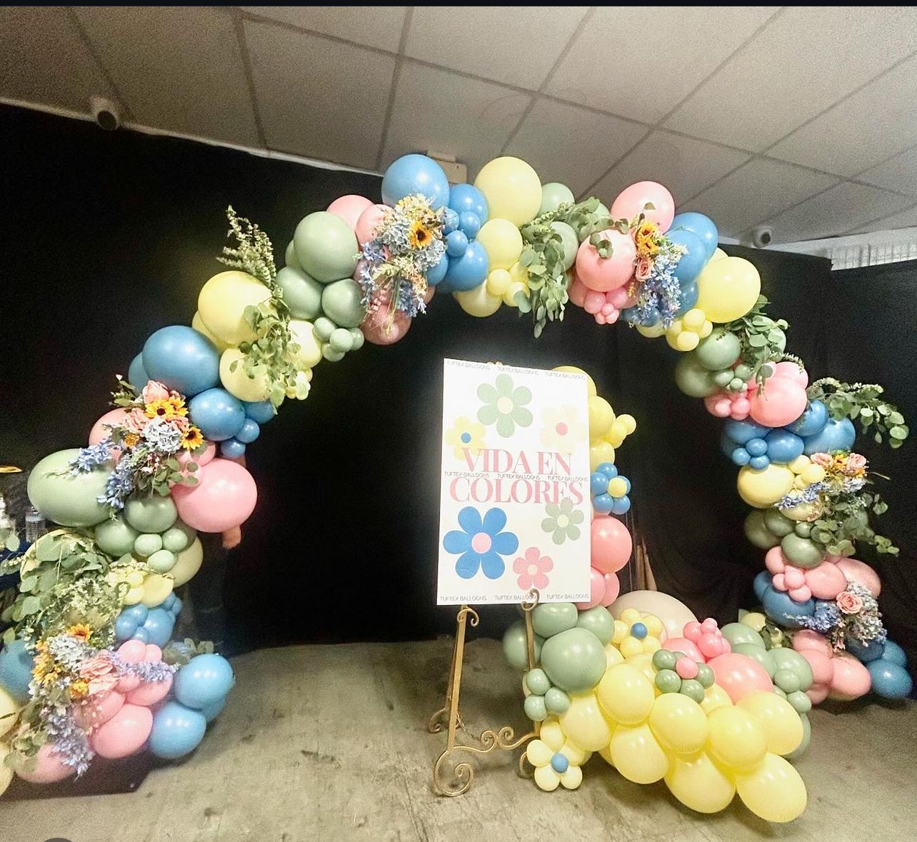 Pastel organic balloon arch with flowers and greenery